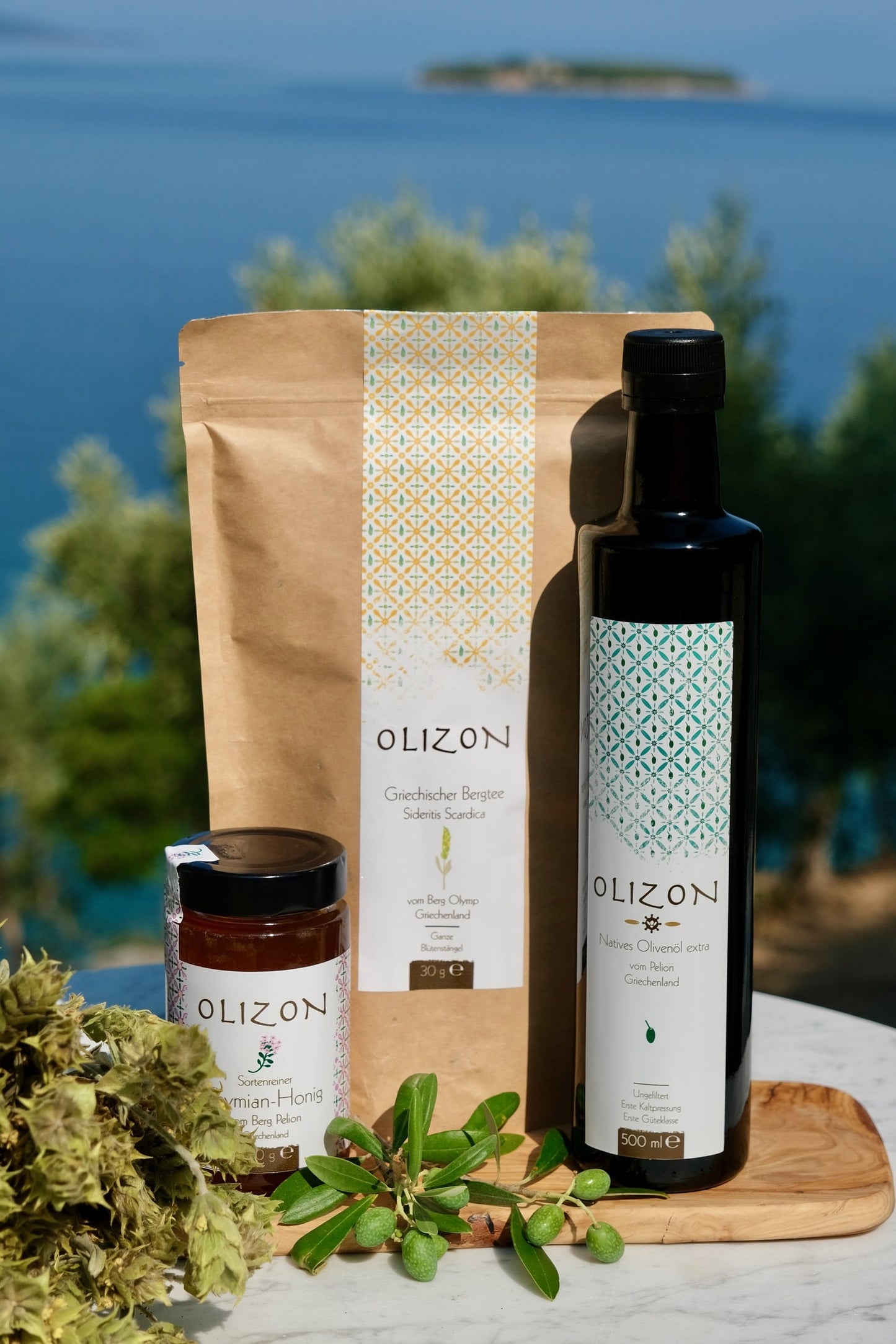 Olizopn Sortimentsbox mit 500 ml extra nativem Olivenöl, 300g Thymian ODER Erdbeerbaumhonig, 30g griechischem Bergtee und einem kleinen Frühstücksbrett aus Olivenholz
